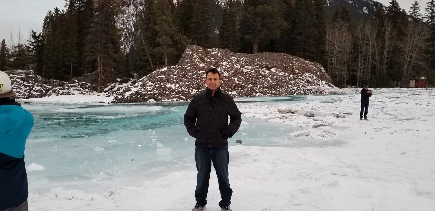 Syed Tirmizi standing beside a frozen river in winter
